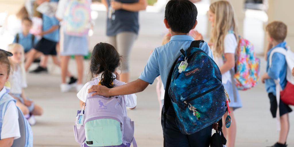 two students walking with arm on shoulder, private school, tampa fla